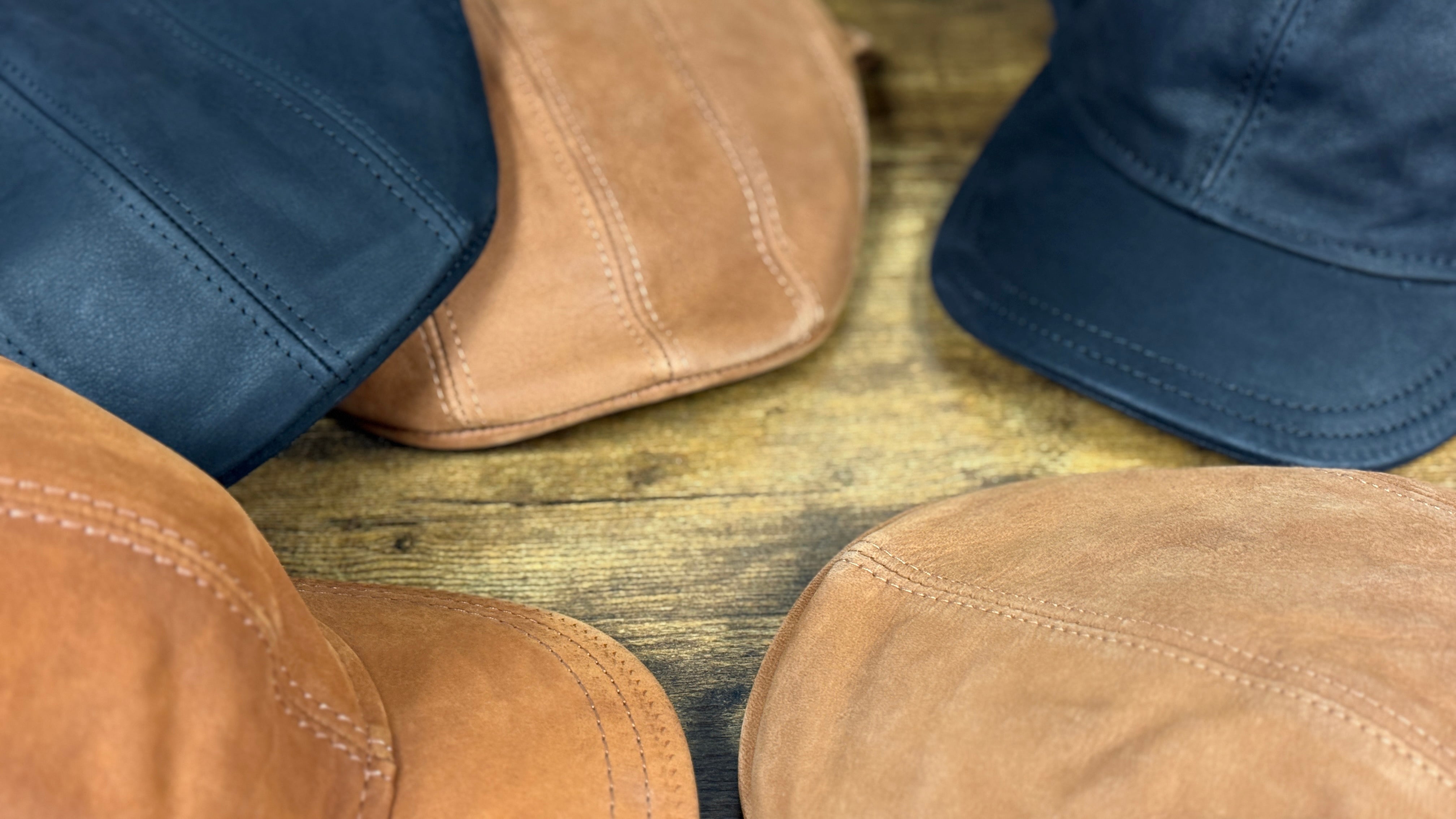 Close-up of cognac and black leather ivy and baseball caps