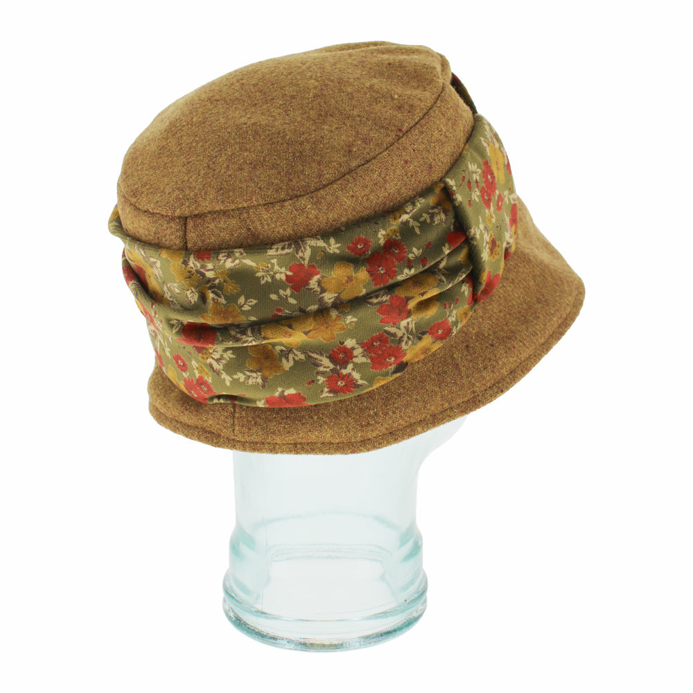 Angled shot of Cassio gold Shetland wool hat with floral velvet trim and packable design