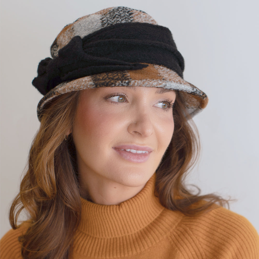 woman wearing neutral toned plaid knitwear hat with black band belfry donata