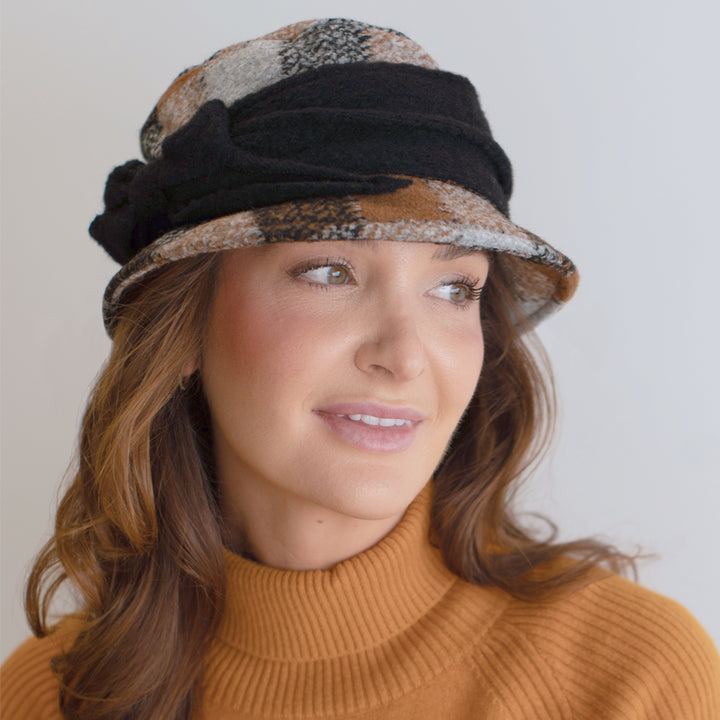 woman wearing neutral toned plaid knitwear hat with black band belfry donata