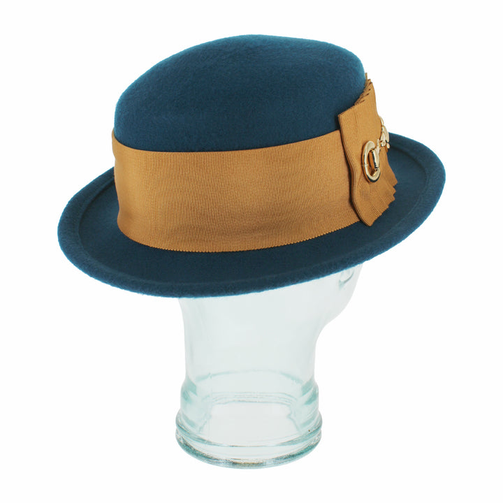 Detailed shot of the Belfry Gardiner teal blue wool boater hat highlighting its gold bow and link trim, semi-packable design, and vintage-inspired shape for autumn and winter