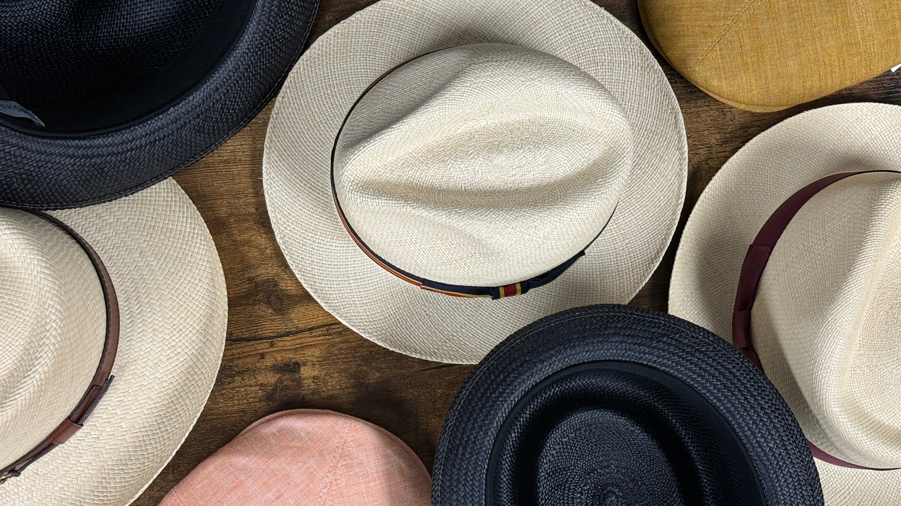 Collection of various hats on a wooden surface