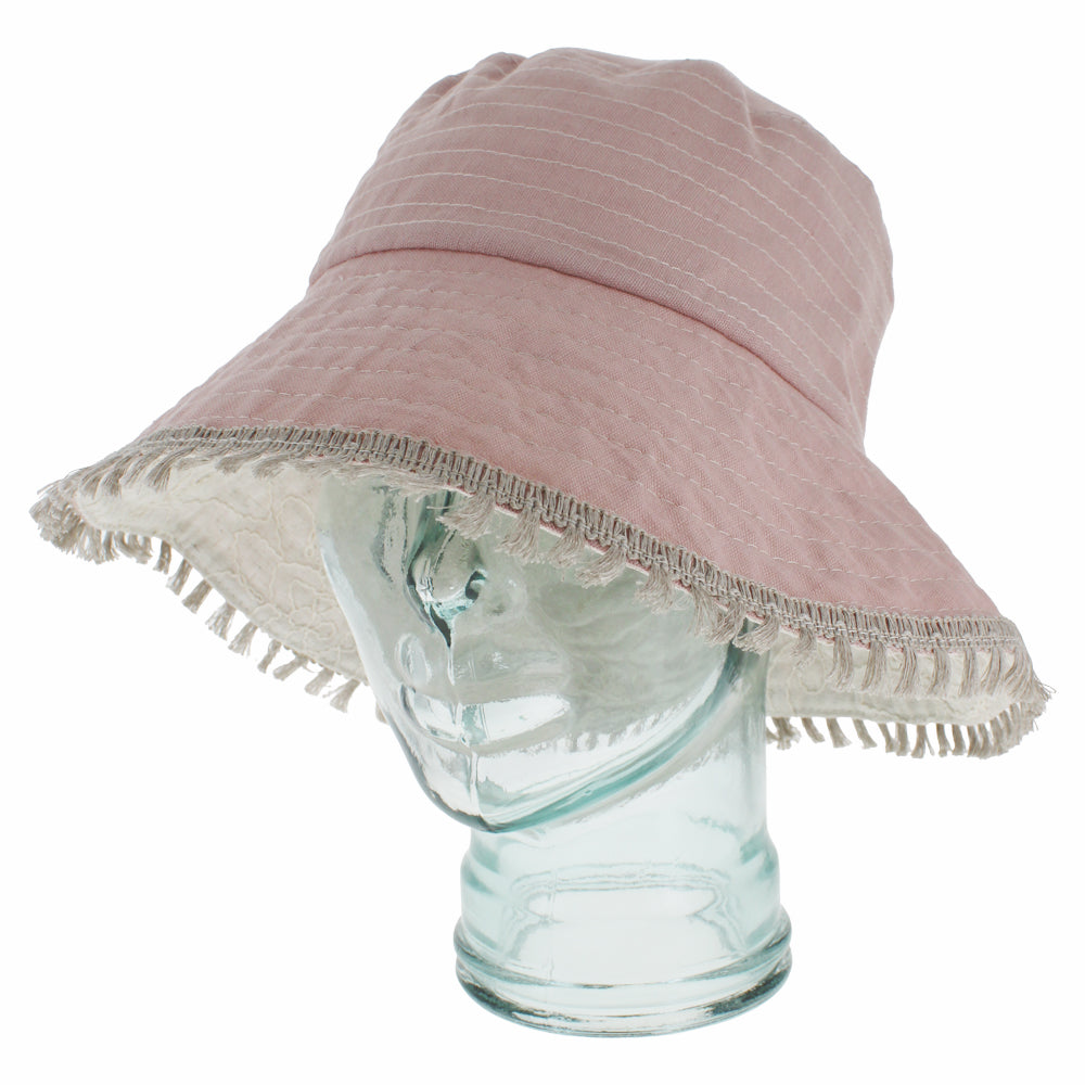 Light pink bucket hat with reversible feature for two in one styling options
