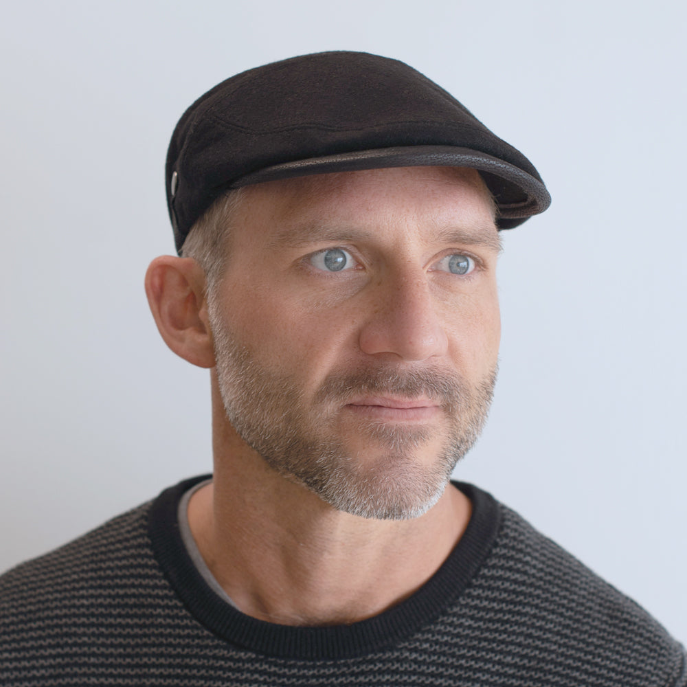 mean wearing black wool cap with black leather trim and silver button on side belfry mancini